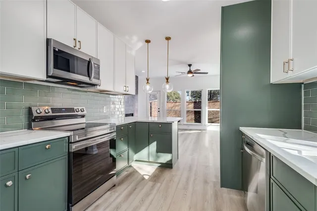 a kitchen with stainless steel appliances a stove a sink and a microwave