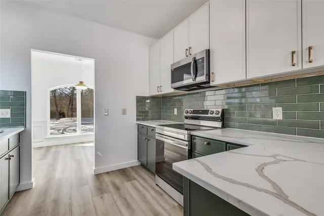 a kitchen with stainless steel appliances granite countertop a stove a sink and a microwave