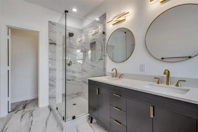 a bathroom with a double vanity sink mirror and shower