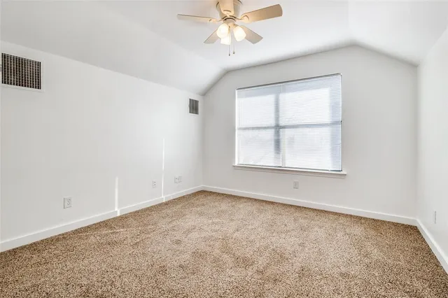 an empty room with a window and a ceiling fan