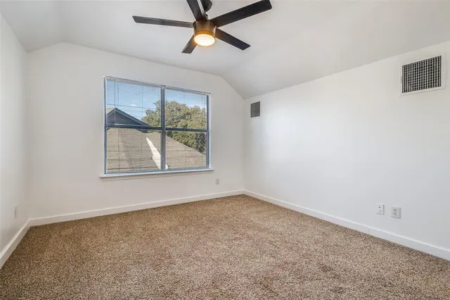 an empty room with windows and ceiling fan