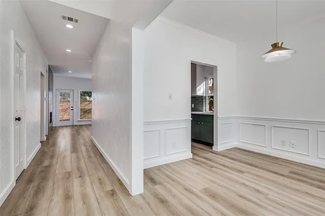 a view of a hallway with wooden floor and closet