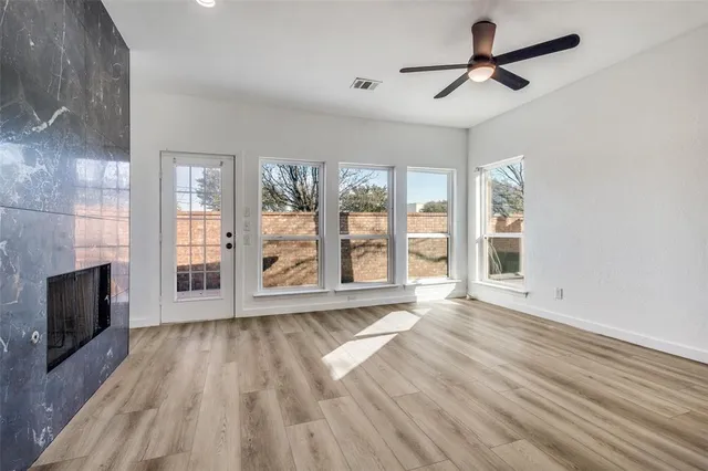 a view of an empty room with a fireplace and a window