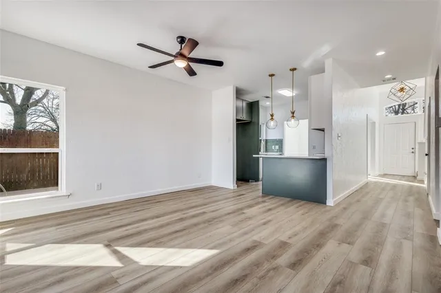 a view of empty room with wooden floor and window