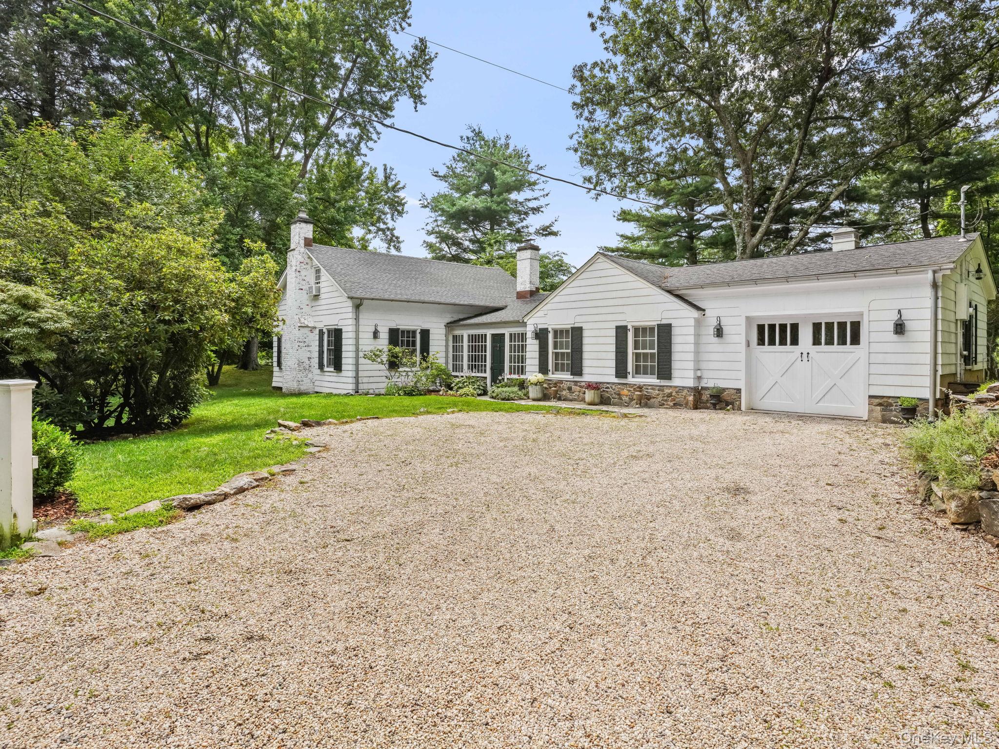 a front view of a house with a yard and potted plants