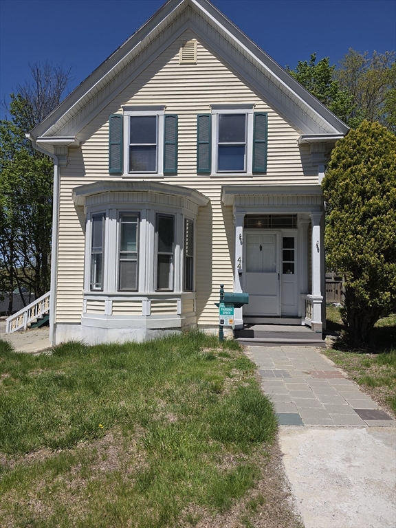 44-th 19th Street, Unit 2 Lowell, MA 01850 - Photo 2 of 5 a front view of a house with a yard