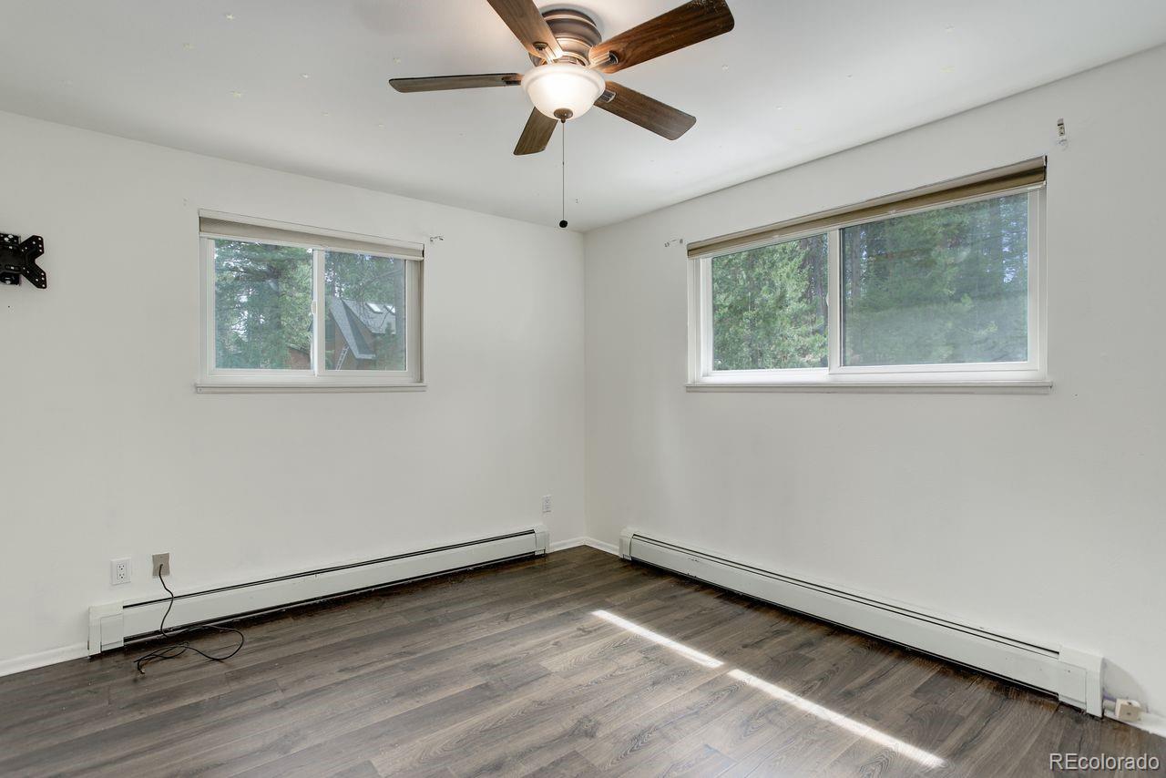 8795 Rudd Road Evergreen, CO 80439 - Photo 14 of 37 a view of an empty room with wooden floor and a window