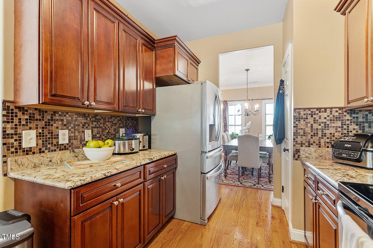 4628 Pat Reed Road Raleigh, NC 27616 - Photo 11 of 34 a kitchen with a refrigerator a stove and wooden cabinets