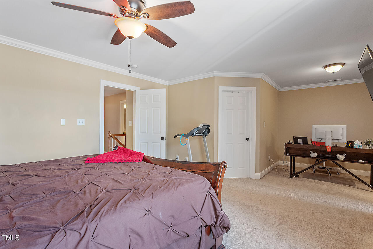 4628 Pat Reed Road Raleigh, NC 27616 - Photo 21 of 34 a bedroom with a bed and a chandelier