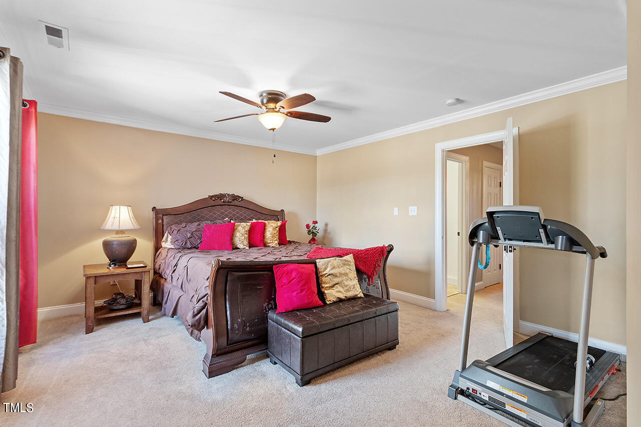 4628 Pat Reed Road Raleigh, NC 27616 - Photo 22 of 34 a bedroom with a bed and a chandelier