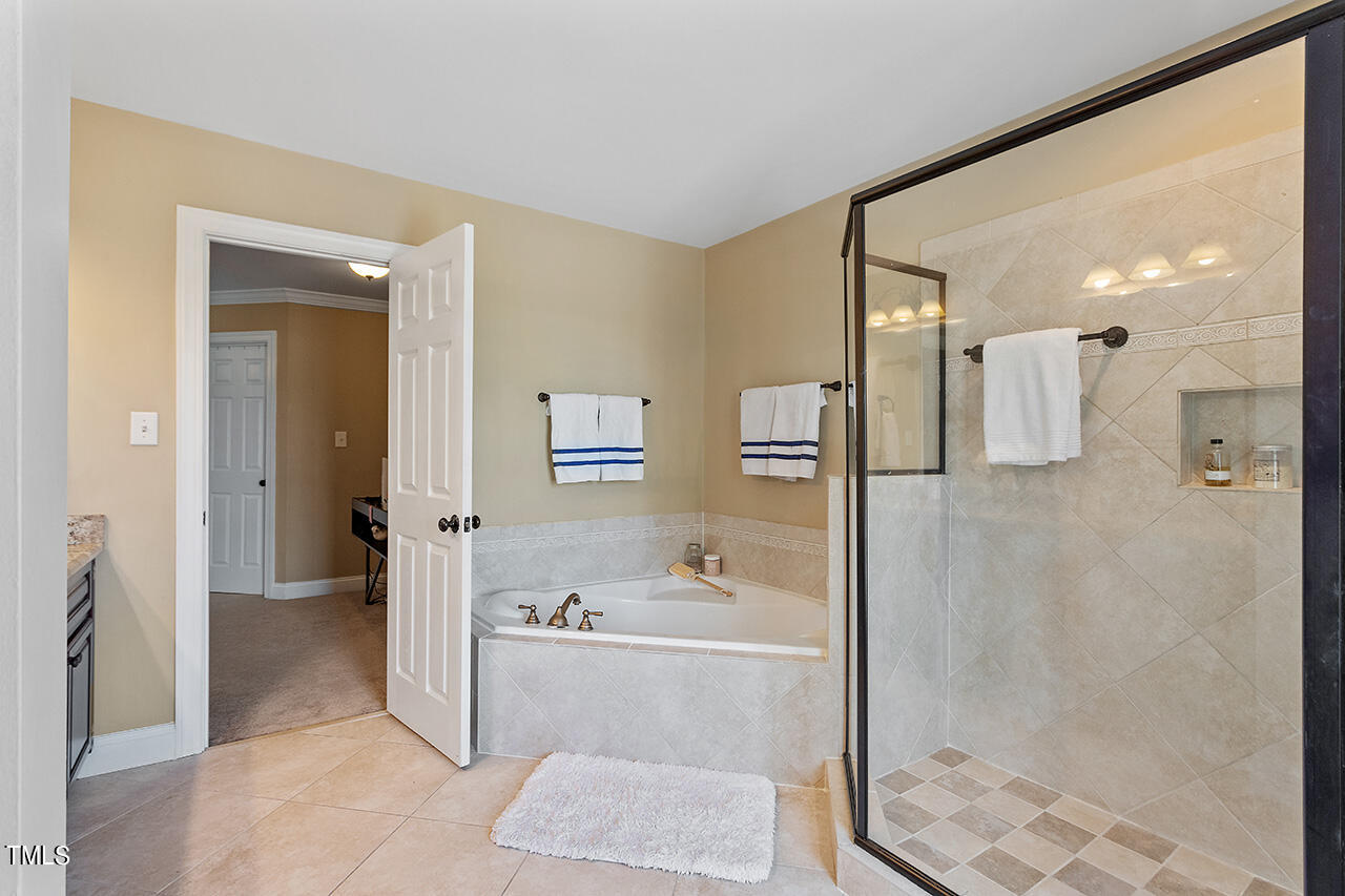 4628 Pat Reed Road Raleigh, NC 27616 - Photo 25 of 34 a bathroom with a bathtub and a shower