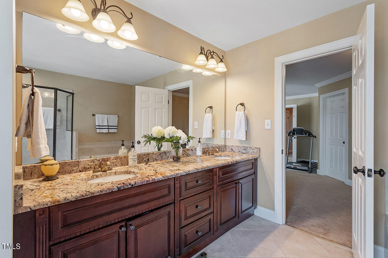 4628 Pat Reed Road Raleigh, NC 27616 - Photo 26 of 34 a bathroom with a granite countertop double vanity sink and a mirror