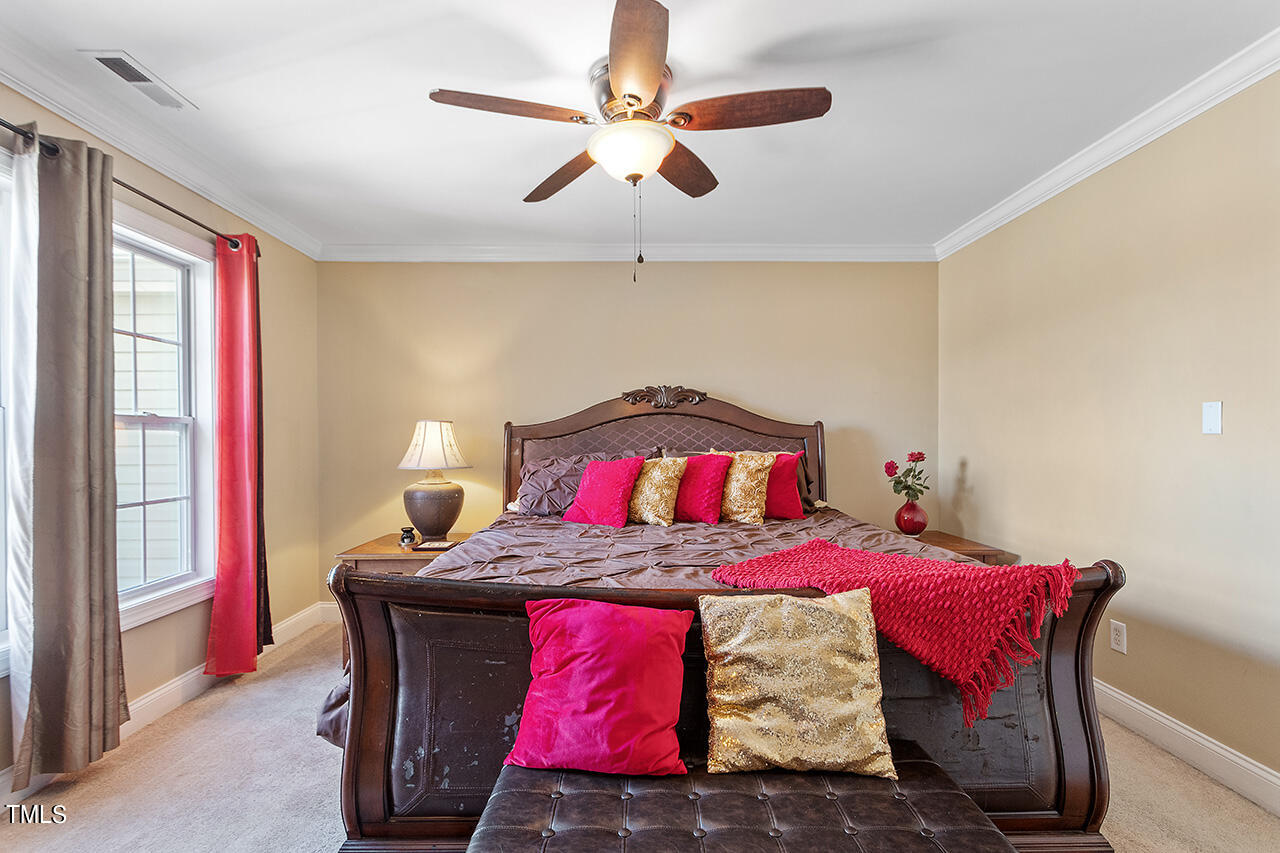 4628 Pat Reed Road Raleigh, NC 27616 - Photo 27 of 34 a bedroom with a bed and a chandelier