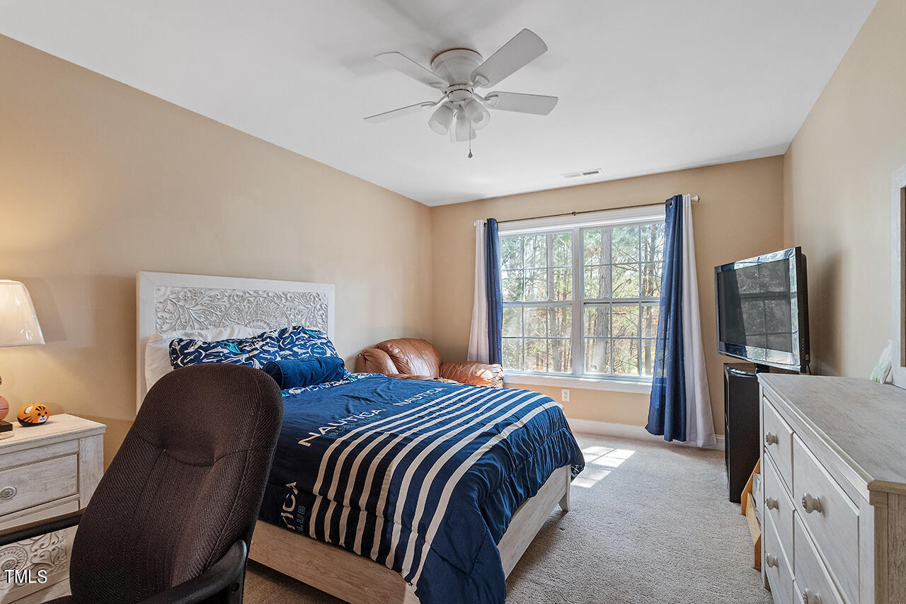 4628 Pat Reed Road Raleigh, NC 27616 - Photo 28 of 34 a bedroom with a bed and a television