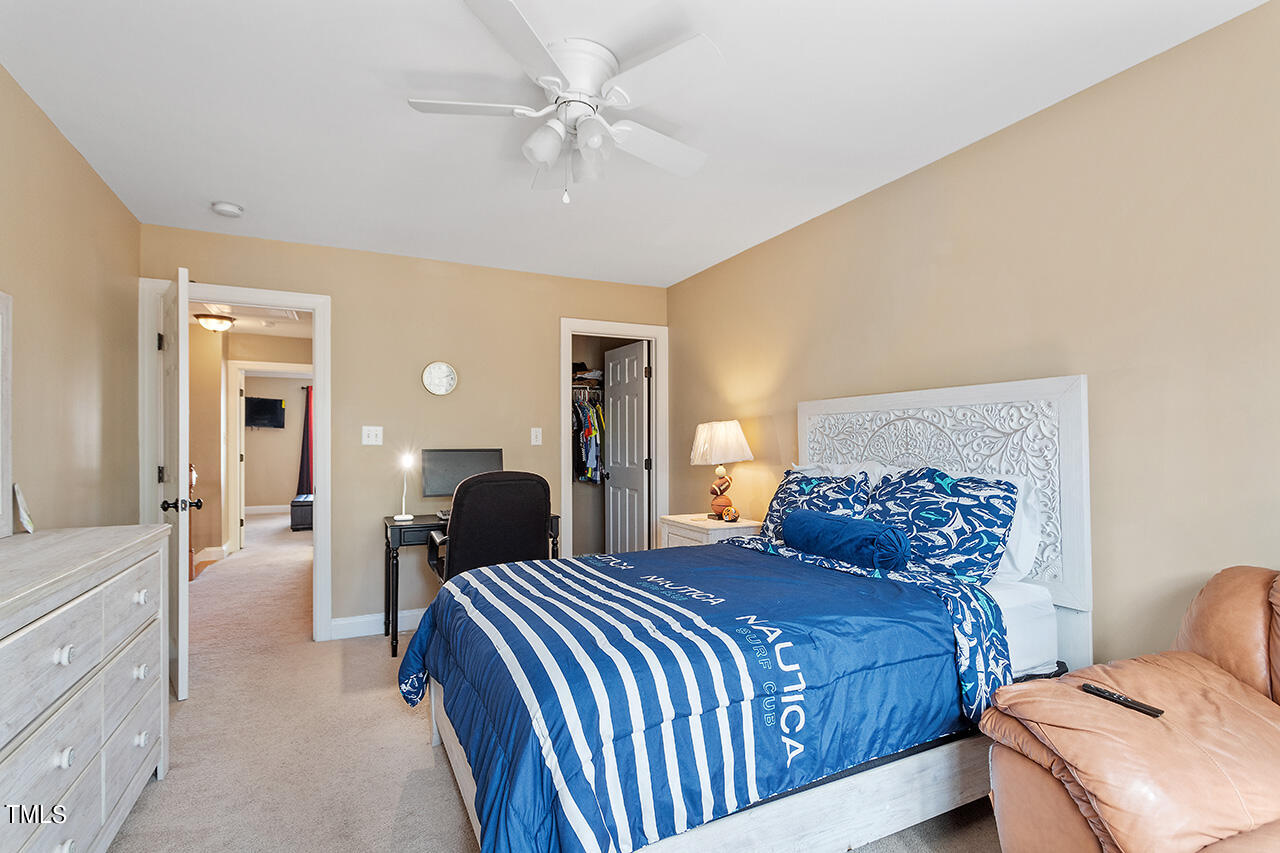 4628 Pat Reed Road Raleigh, NC 27616 - Photo 29 of 34 a bedroom with a bed and a chandelier