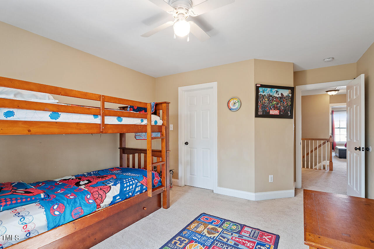 4628 Pat Reed Road Raleigh, NC 27616 - Photo 31 of 34 a bedroom with a bed and a chandelier