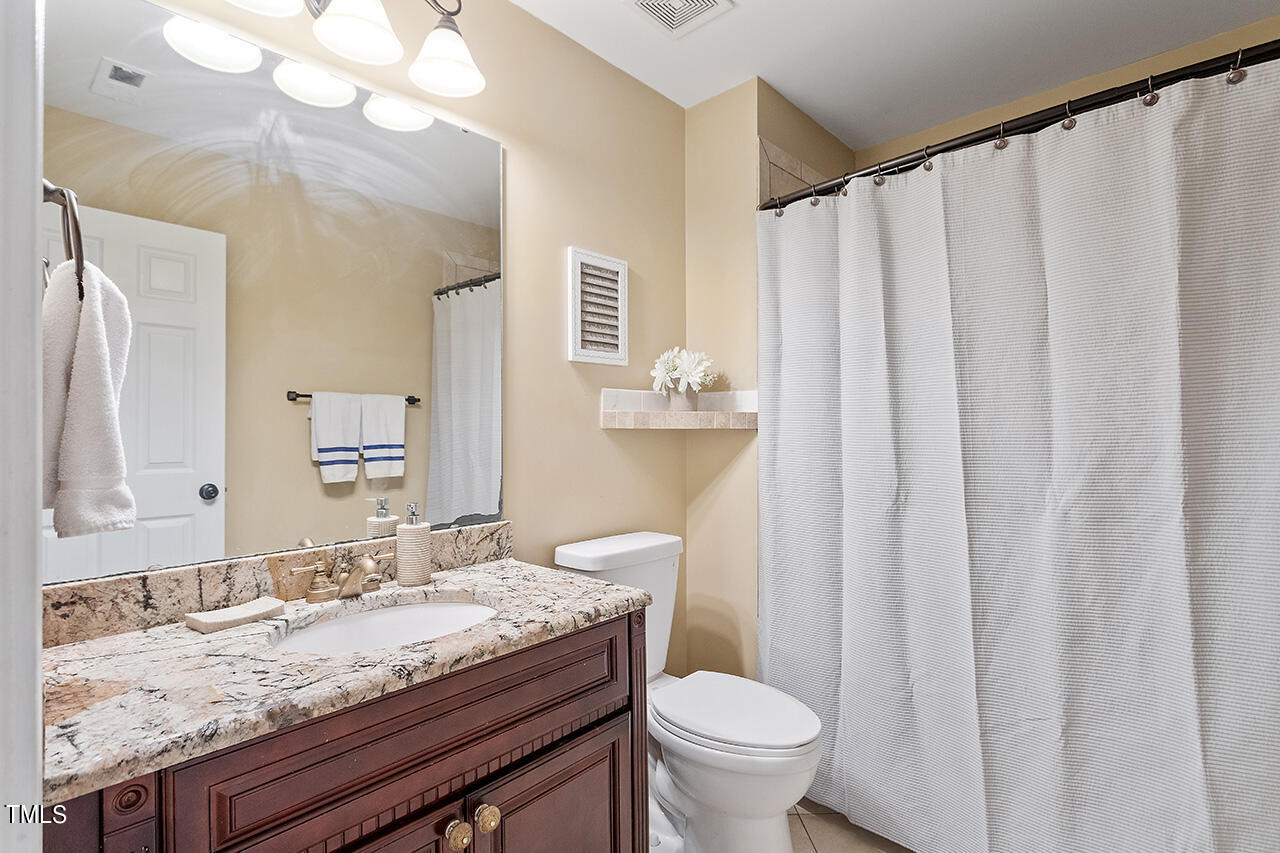 4628 Pat Reed Road Raleigh, NC 27616 - Photo 32 of 34 a bathroom with a granite countertop sink and a mirror