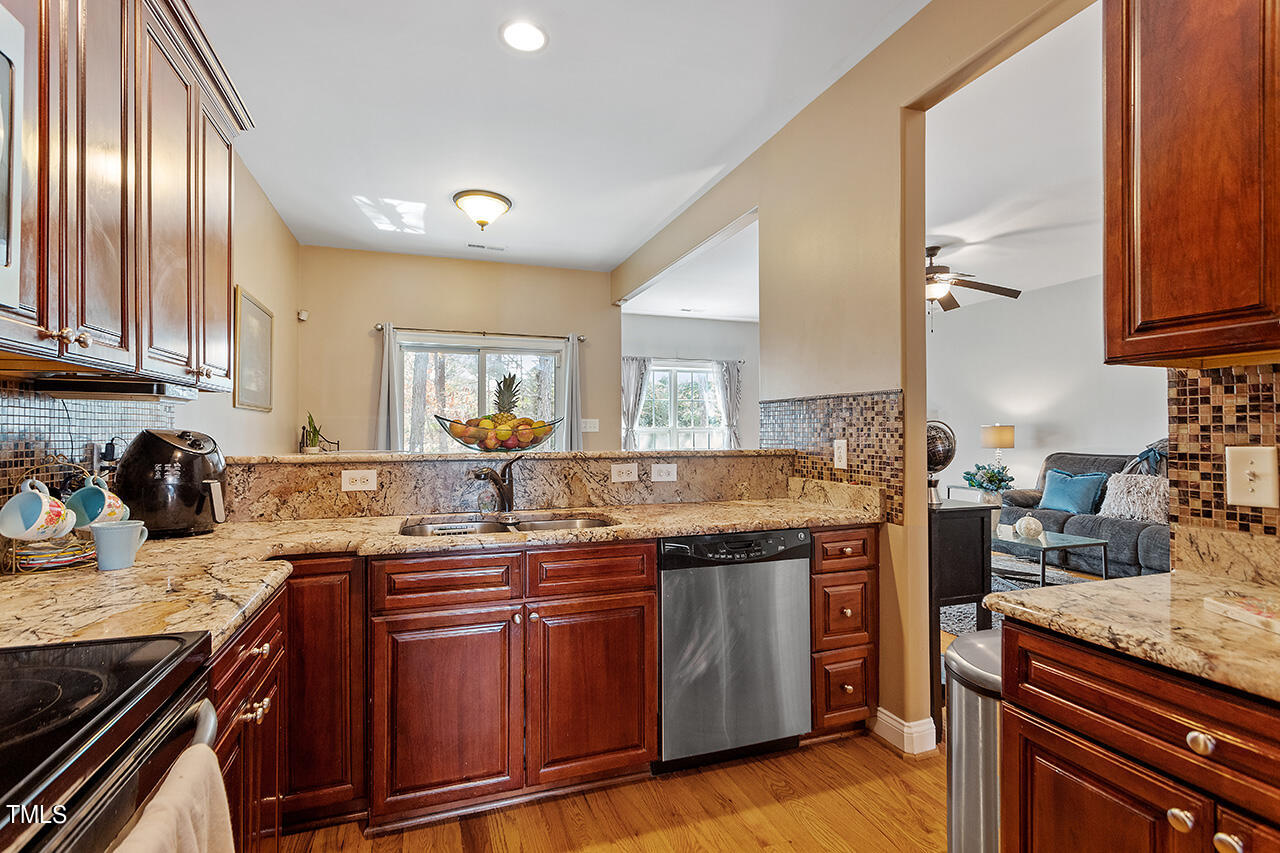 4628 Pat Reed Road Raleigh, NC 27616 - Photo 10 of 34 a kitchen with kitchen island granite countertop wooden cabinets and a sink