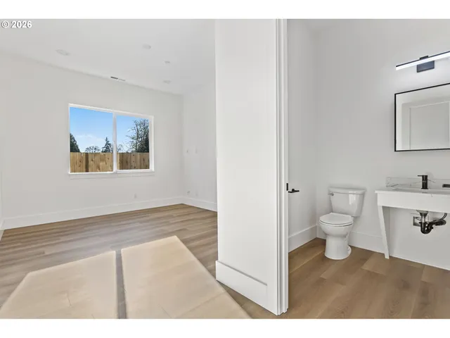 a bathroom with a toilet sink a mirror and vanity
