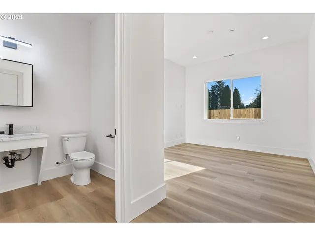 a bathroom with a toilet sink a mirror and vanity