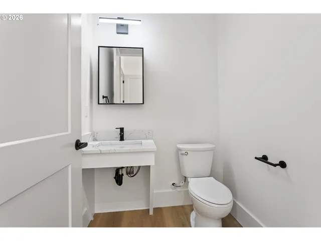 a bathroom with a toilet sink vanity and mirror