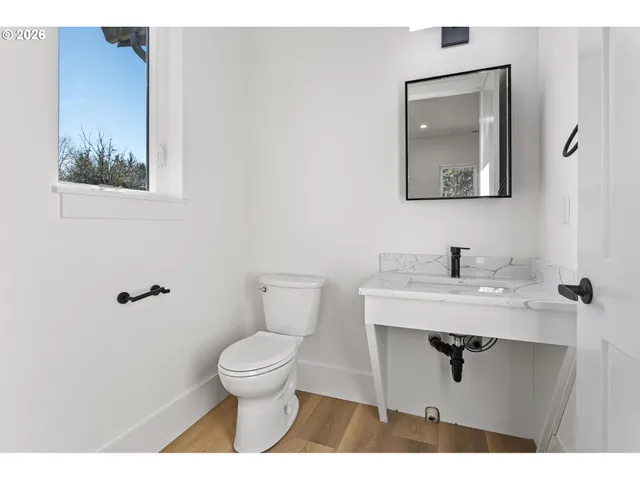 a bathroom with a toilet a sink and mirror