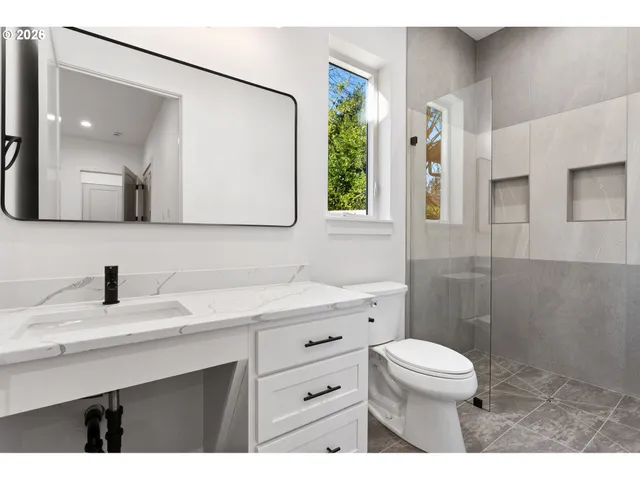 a bathroom with a sink a toilet and a mirror