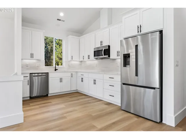 a kitchen with white cabinets and stainless steel appliances