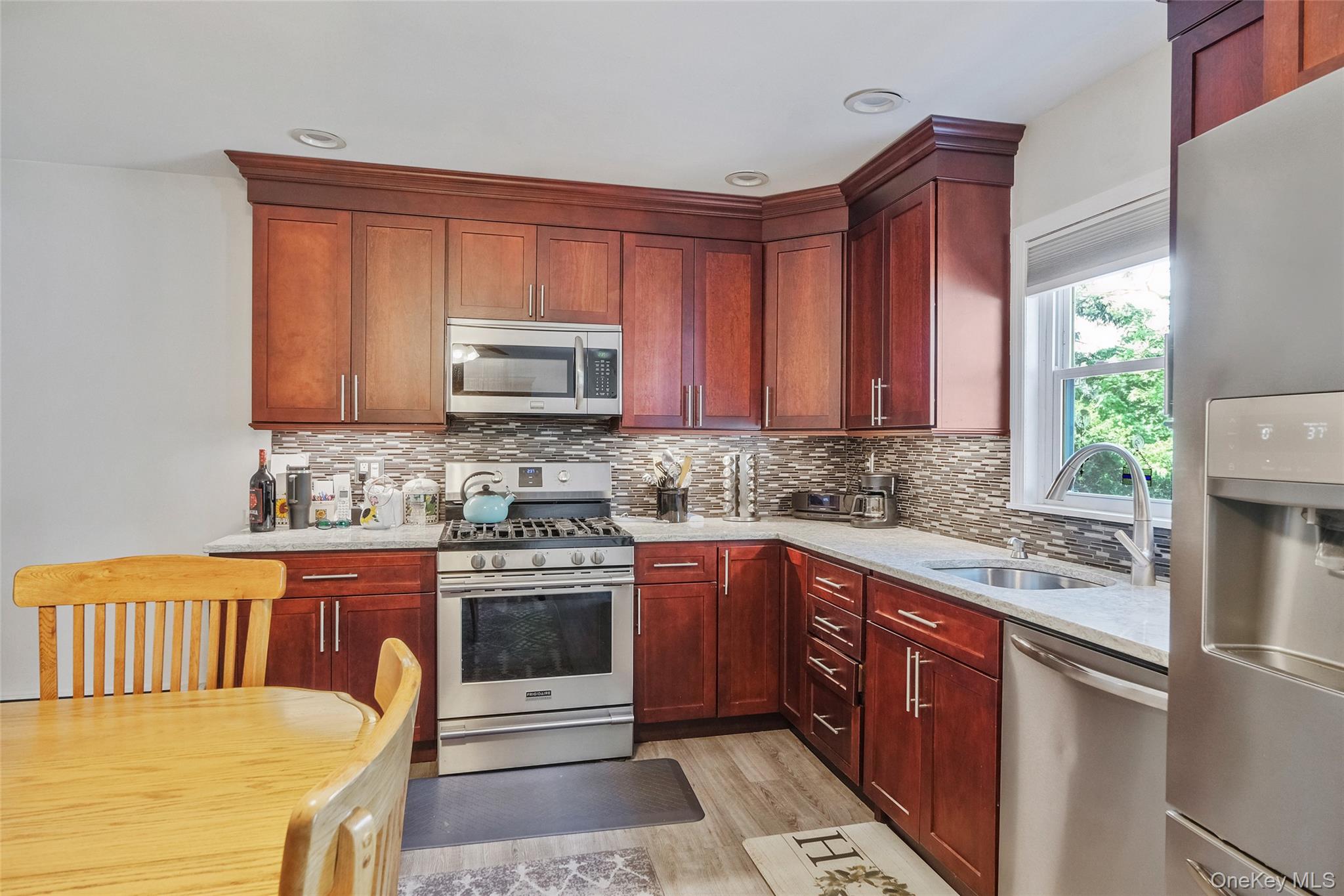 59 Maybrook Road North Babylon, NY 11703 - Photo 29 of 43 a kitchen with stainless steel appliances granite countertop a sink stove and microwave