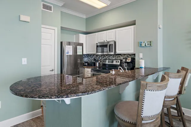 a kitchen with stainless steel appliances granite countertop a sink and a refrigerator