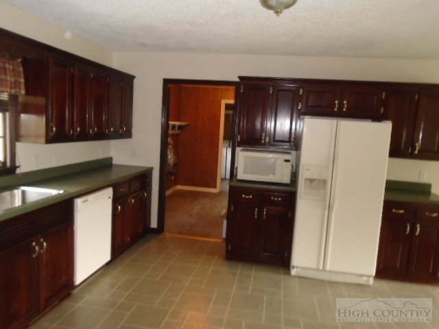 717 A Deep Ford Road Lansing, NC 28643 - Photo 10 of 18 a kitchen with stainless steel appliances granite countertop a refrigerator and a sink