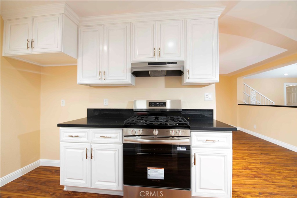 143 West 234th Place Carson, CA 90745 - Photo 26 of 46 a kitchen with stainless steel appliances granite countertop a stove and a white cabinets