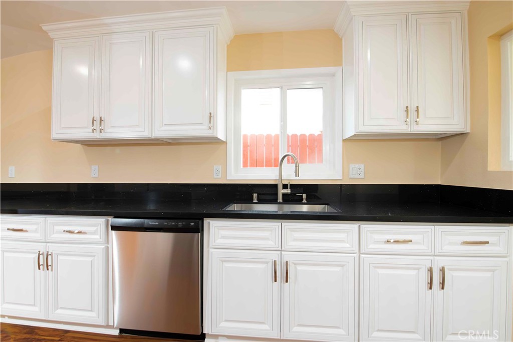 143 West 234th Place Carson, CA 90745 - Photo 27 of 46 a kitchen with granite countertop white cabinets and sink