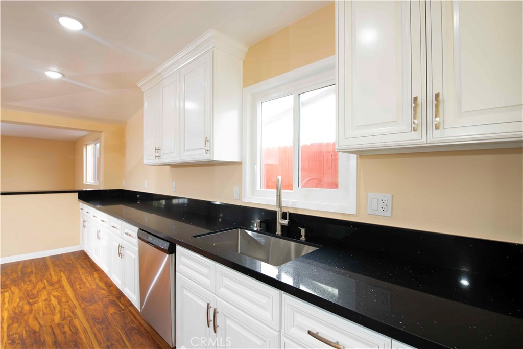 143 West 234th Place Carson, CA 90745 - Photo 28 of 46 a kitchen with granite countertop sink and cabinets