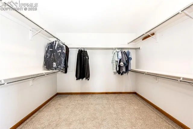a view of walk in closet with clothes and shoes