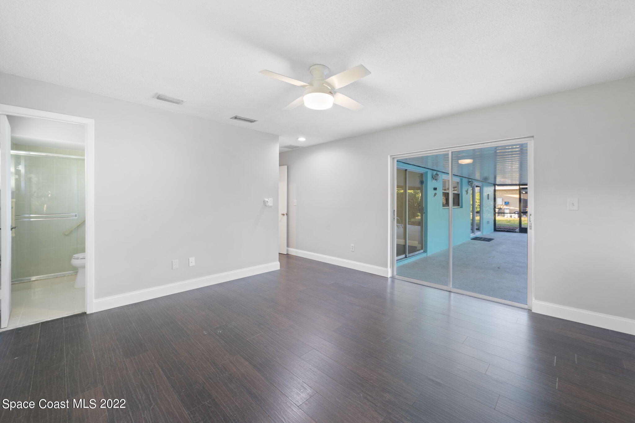 1141 Cromey Road Northeast Palm Bay, FL 32905 - Photo 12 of 27 an empty room with wooden floor and mirror