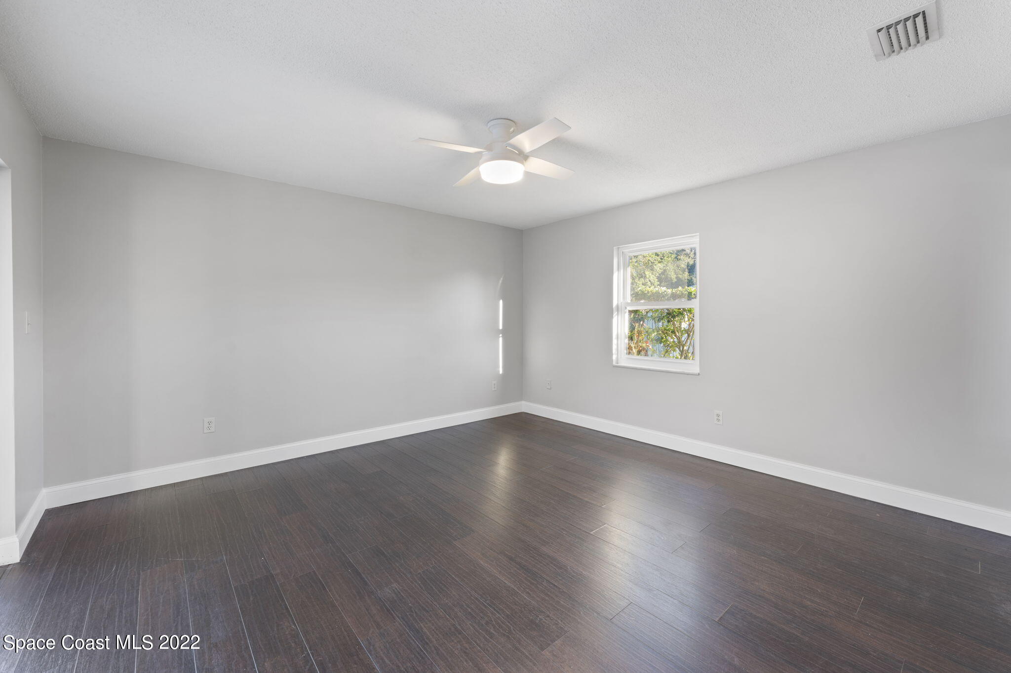 1141 Cromey Road Northeast Palm Bay, FL 32905 - Photo 14 of 27 an empty room with wooden floor and windows