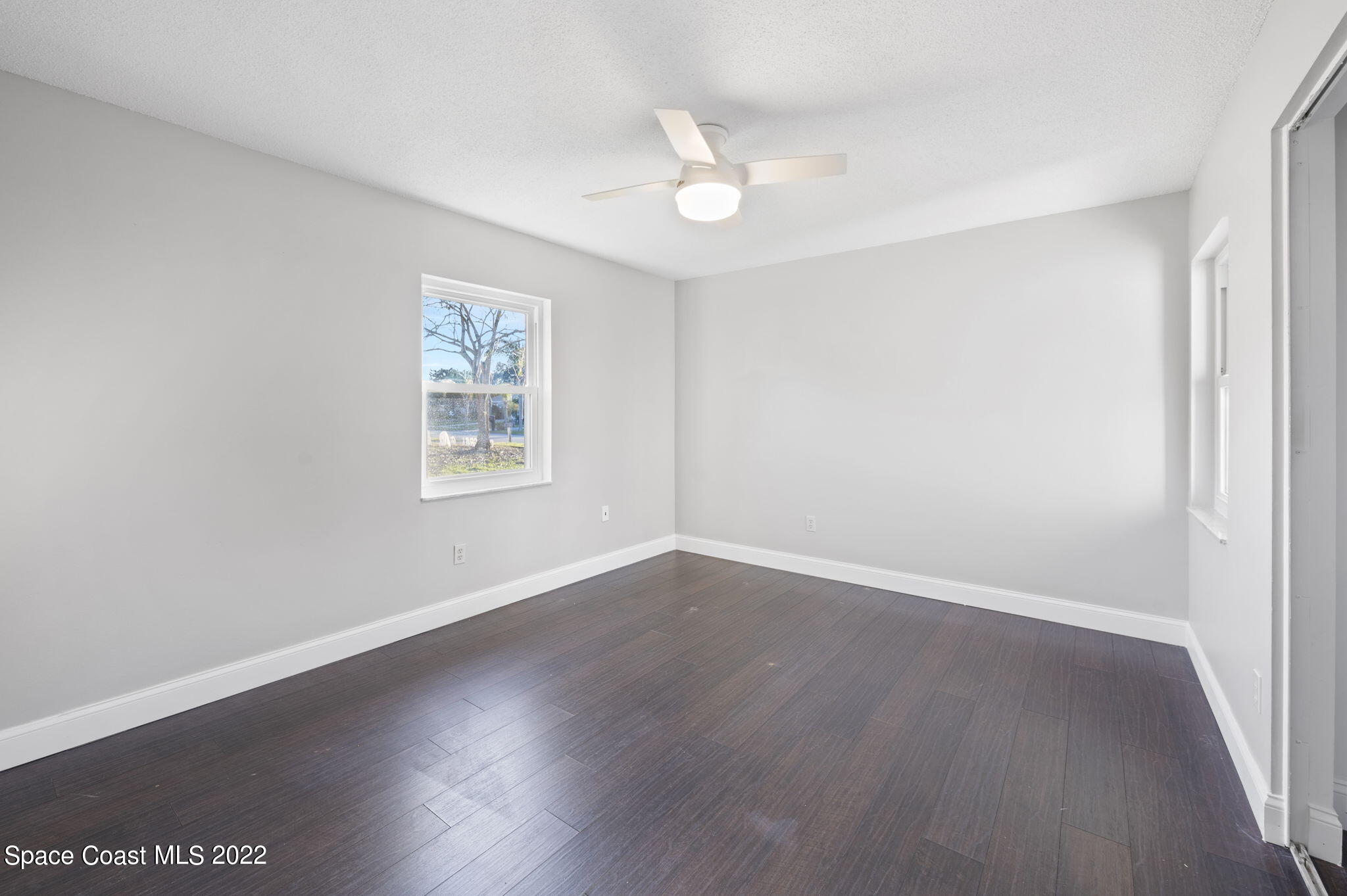 1141 Cromey Road Northeast Palm Bay, FL 32905 - Photo 17 of 27 an empty room with wooden floor and windows