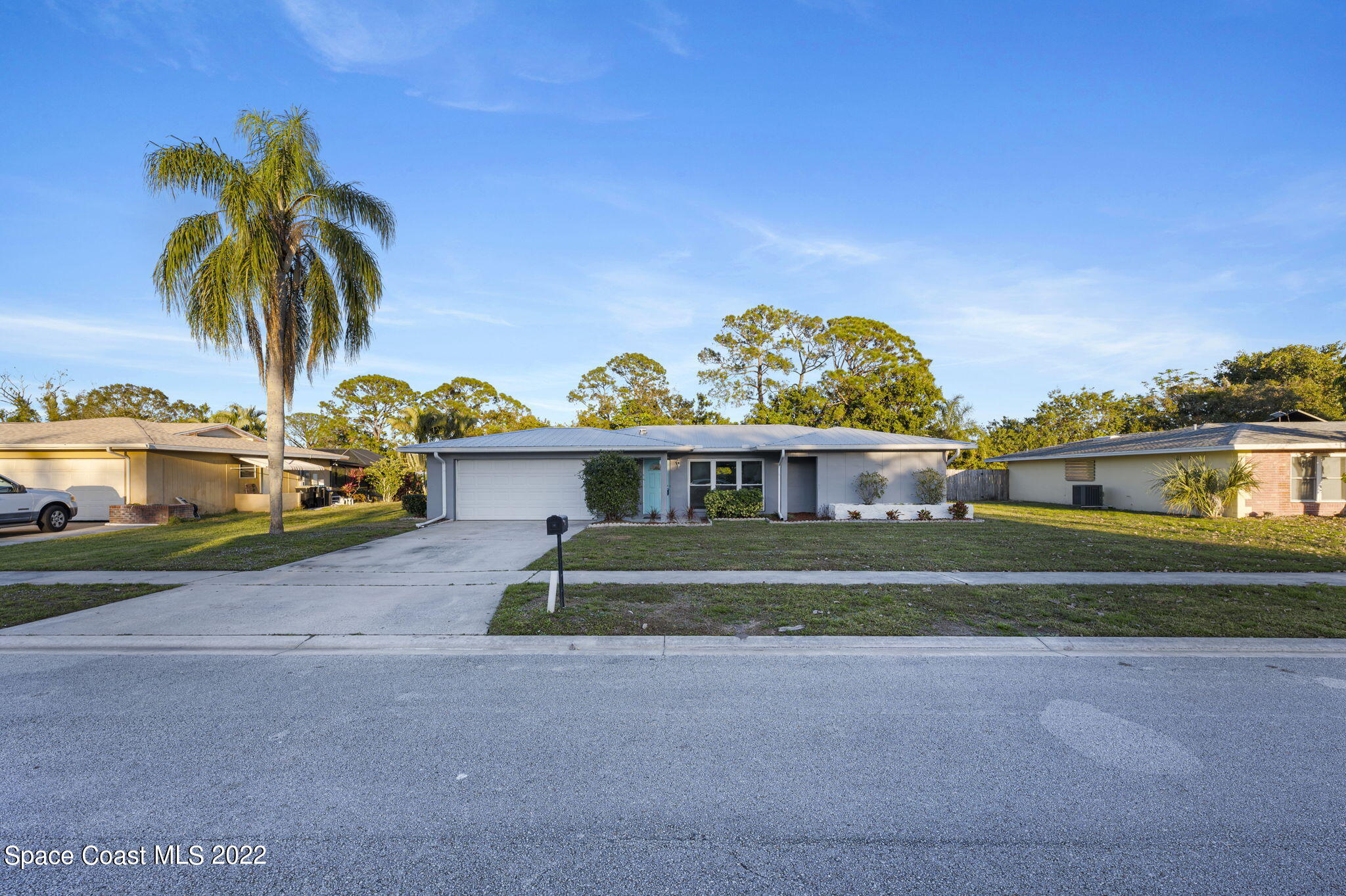 1141 Cromey Road Northeast Palm Bay, FL 32905 - Photo 22 of 27 a front view of a house with a garden and a yard