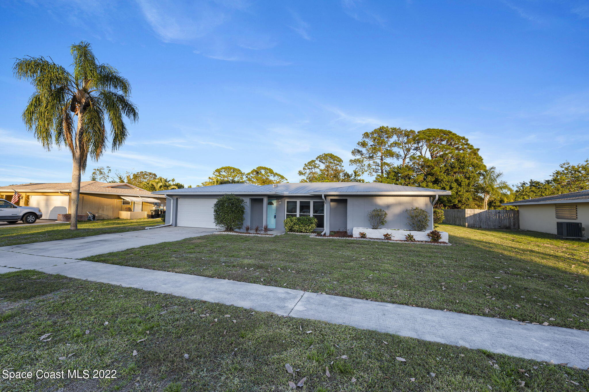1141 Cromey Road Northeast Palm Bay, FL 32905 - Photo 24 of 27 a front view of a house with a yard and garage