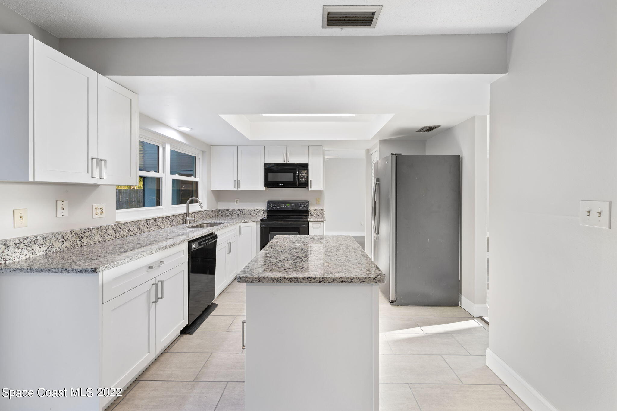 1141 Cromey Road Northeast Palm Bay, FL 32905 - Photo 9 of 27 a kitchen with stainless steel appliances granite countertop a stove and a refrigerator