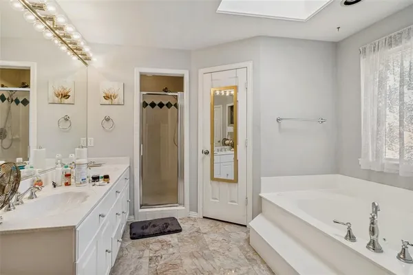 a spacious bathroom with a tub sink and mirror
