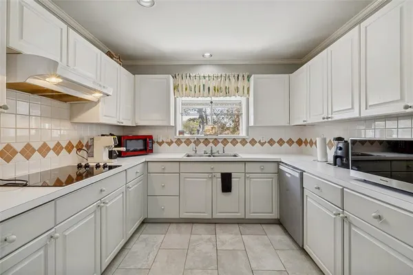 a kitchen with granite countertop white cabinets and white appliances