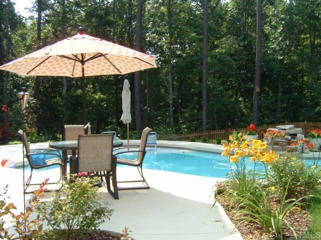 8692 Barrett Ridge Road Wake Forest, NC 27587 - Photo 10 of 12 Extensive pool area landscaping includes a stone water feature, large patio area, perennial gardens, and a fenced backyard.