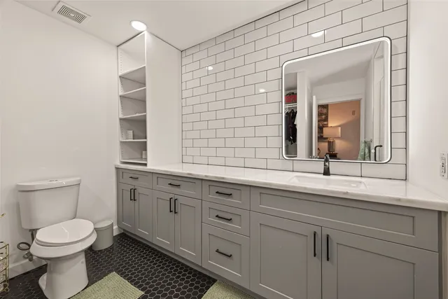 a spacious bathroom with 2 sink and a mirror