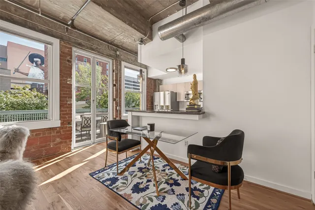 a kitchen with stainless steel appliances kitchen island granite countertop a table chairs and a refrigerator