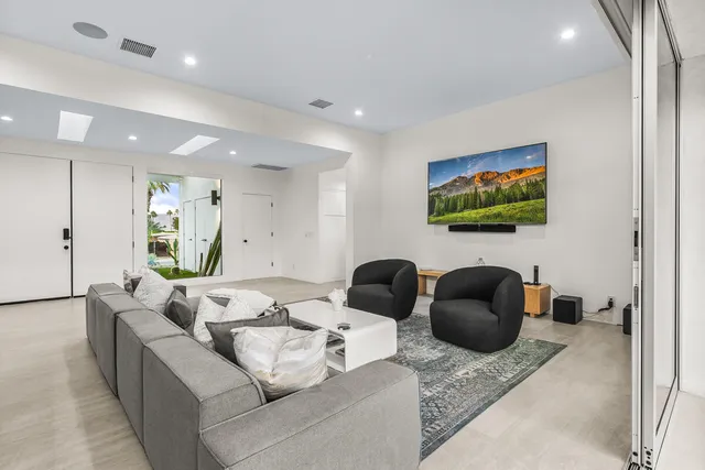 a kitchen with stainless steel appliances a sink a stove a refrigerator cabinets and a dining table