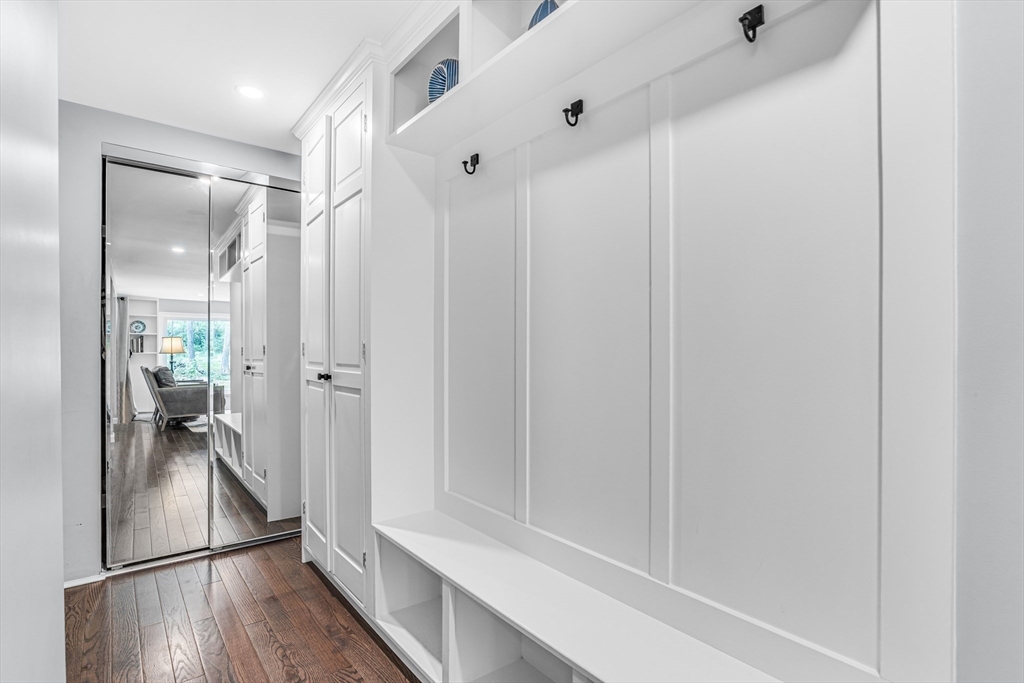 121 Shade Street Lexington, MA 02421 - Photo 18 of 42 a view of a hallway with wooden floor and a living room
