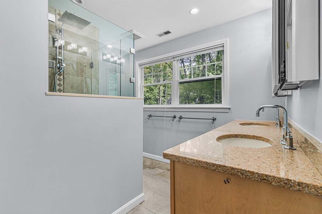 121 Shade Street Lexington, MA 02421 - Photo 24 of 42 a bathroom with a granite countertop sink a mirror and a bathtub