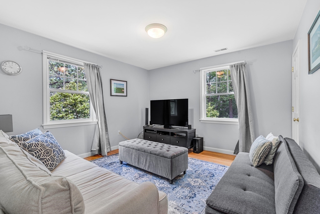 121 Shade Street Lexington, MA 02421 - Photo 27 of 42 a bedroom with furniture and a flat screen tv